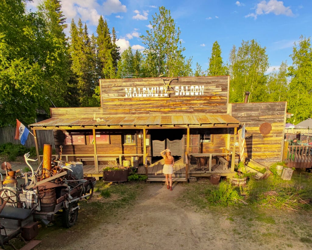 Woman outside the Malamute Saloon, one of the best things to do in Fairbanks Alaska.