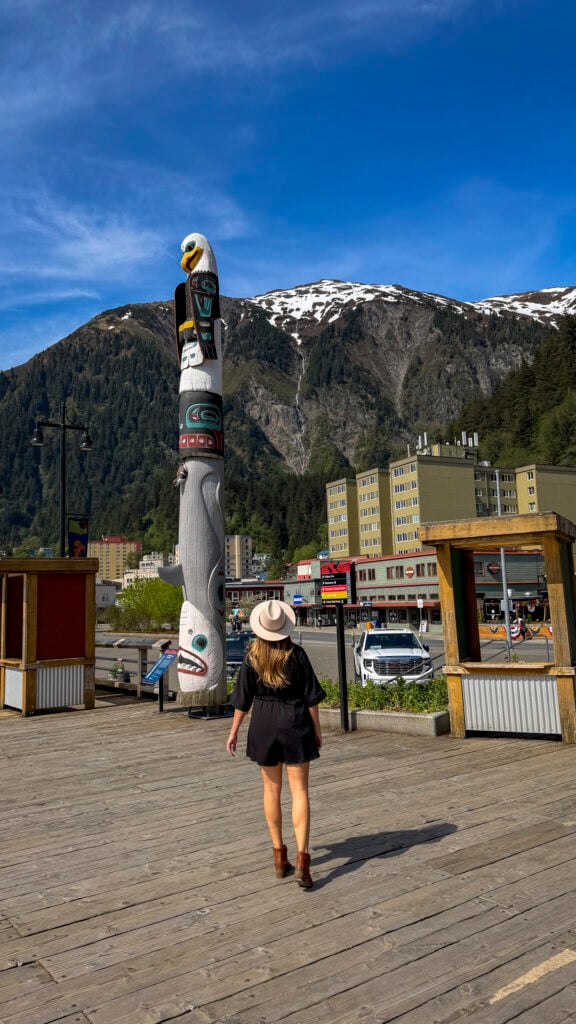 Women next to a totem pole - Things to do in Juneau Alaska from a cruise ship.