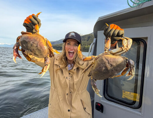 Woman holding crabs from the Into Alaska crabbing tour in Juneau, Alaska.